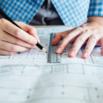 Architect or engineer working in office on blueprint. Architects